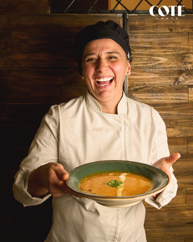 La chef Cote sonriendo con una crema de zapallo en las manos