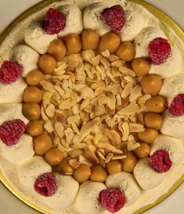 Torta casera vista desde arriba con frambuesas y almendras tostadas